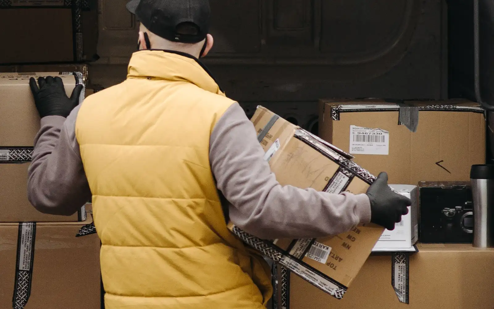 A worker loading labelled cartons into a delivery van