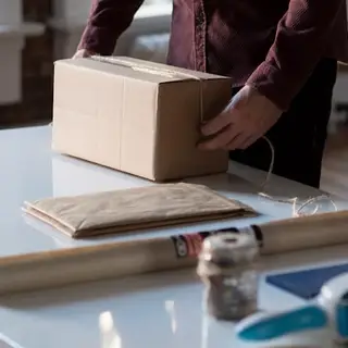 Hands wrapping kraft-paper gift parcels
